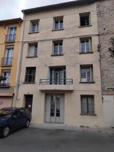 a building with a car parked in front of it at Appartement de Ville Médiévale in Vinça