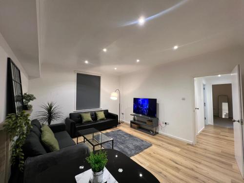 a living room with a couch and a flat screen tv at 2BR Apartment - LuxeSuites - City Centre in Midland