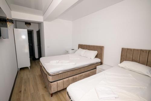 two beds in a room with white walls and wooden floors at Miraky Beach in Văleni