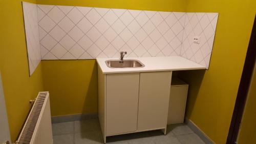 a bathroom with a sink and yellow walls at Premier Inn Apartments in Budapest