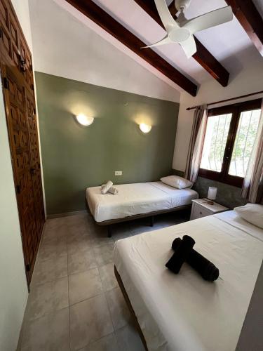 a bedroom with two beds and a ceiling fan at Villa Relax24 - Luxury Villa in Val de Pop in Alcalalí