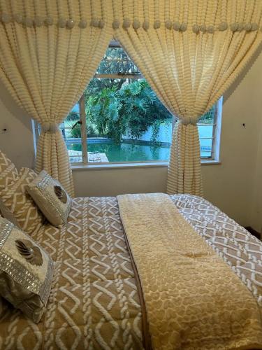 a bedroom with a bed with curtains and a window at Hesed - Mandla Upgraded! in Sandton