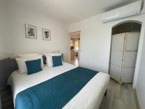 une chambre avec un grand lit avec des oreillers bleus et blancs dans l'établissement Nid douillet a la campagne, à Saint-Jean-de-Bournay