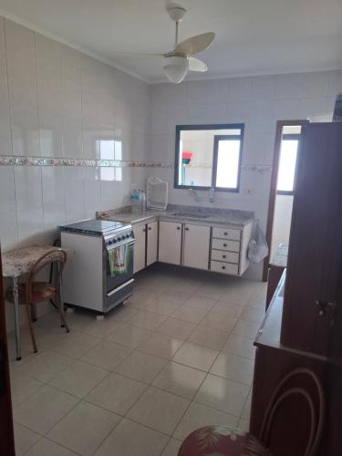 a kitchen with a stove and a sink at Apartamento Aconchegante 70m praia in Mongaguá