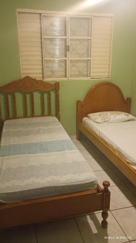 two beds in a room with green walls at RECANTO DA IZAURINHA in Olímpia