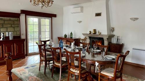 a dining room with a table and chairs and a fireplace at Casa do Cabo Alto