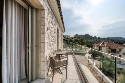 a balcony with a table and chairs looking out at the mountains at PALELIA living in the olive garden in Nafplio