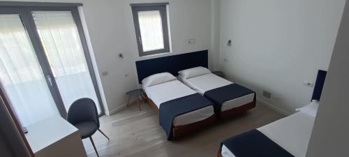 a small bedroom with two beds and a window at Hotel Everest Arco in Arco