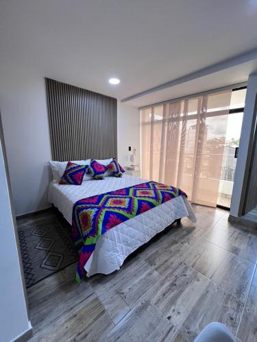 a bedroom with a bed and a large window at Meraki Urban Lofts in Quibdó