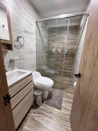 a bathroom with a shower and a toilet and a sink at Meraki Urban Lofts in Quibdó