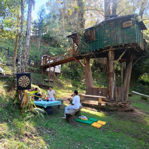 グアルネにあるCasa en el Arbol y Campingのツリーハウスのテーブルに座っている男性グループ