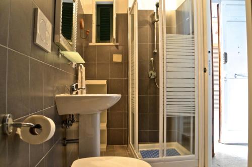 a bathroom with a toilet and a sink and a shower at La Rue in Tortoreto Lido