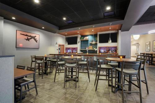a restaurant with tables and chairs and a bar at Drury Inn & Suites Dayton North in Dayton