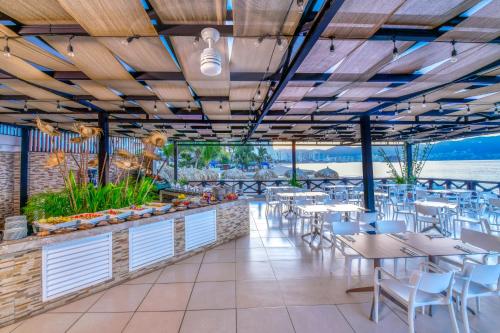 a restaurant with tables and chairs and a view of the ocean at Krystal Beach Acapulco in Acapulco