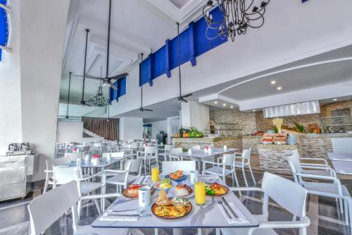 a dining room with white tables and white chairs at Krystal Beach Acapulco in Acapulco