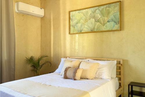 a bed with white sheets and pillows in a bedroom at Villavida Boutique Hotel - La Playita in Las Galeras