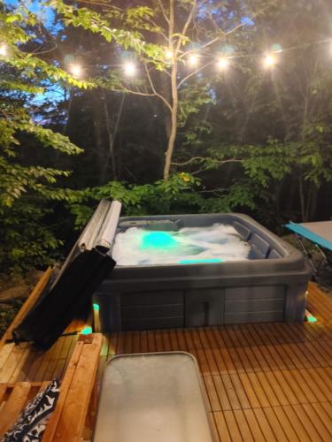 a hot tub on a deck at night with lights at Chalet AYUR - SPA et nature in La Minerve