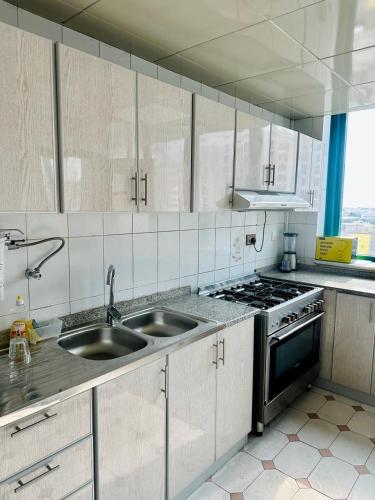 una cucina con lavello e fornelli di Karimz Backpackers a Abu Dhabi