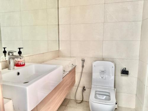 um banheiro branco com uma pia e um vaso sanitário em Luxury studio appartment em Sabkhah