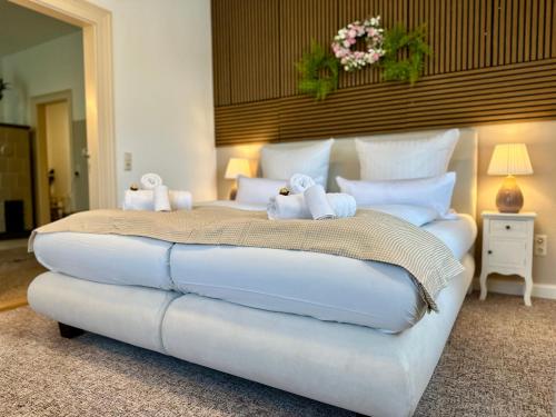 a large white bed with two stuffed animals on it at Belvedere Apartment - Riverside - Zentrum - Netflix - Liliensteinblick in Königstein an der Elbe