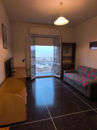 a living room with a couch and a sliding glass door at Casa Fannì Comodità, vista mozzafiato, parcheggio in Varazze