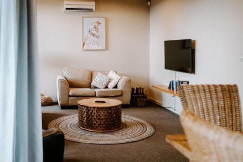 a living room with a couch and a coffee table at Te Mata Views Resort in Havelock North