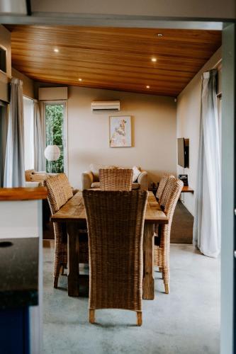a dining room with a table and wicker chairs at Te Mata Views Resort in Havelock North