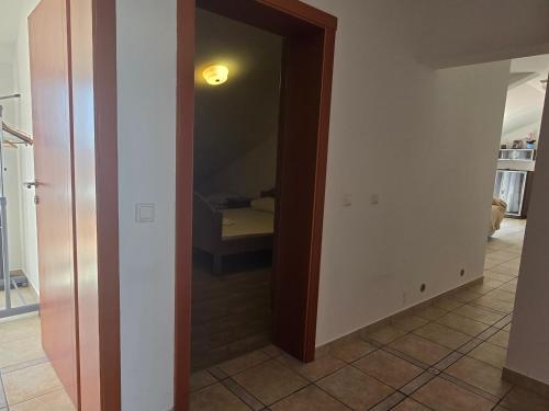 un pasillo con una puerta que conduce a una habitación con cama en Apartment More, en Novalja