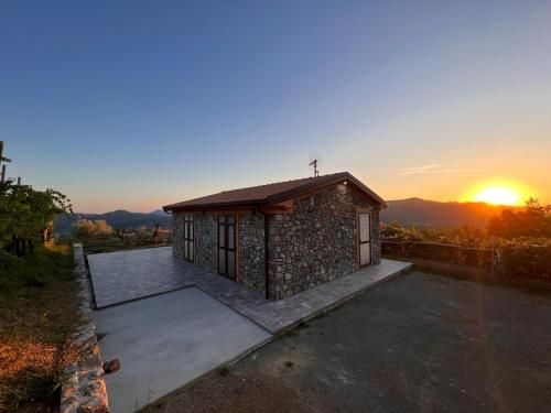 a small building with a sunset in the background at La Madonnina-house in the Bolano vineyard in Bolano