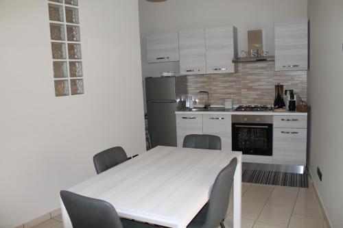 a kitchen with a white table and chairs at A casa di Giulia in Cinquefrondi
