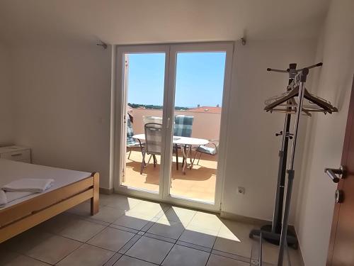 Habitación con una gran puerta corredera de cristal con una mesa. en Apartment More, en Novalja