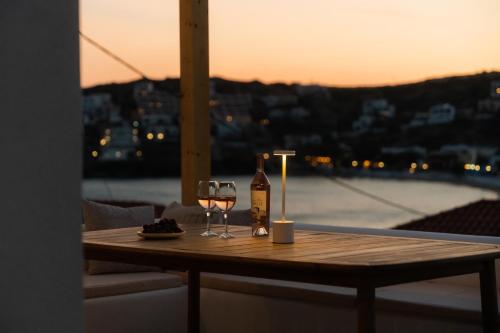 a table with a bottle of wine and a glass at Noleya Pure Island Stay in Batsi