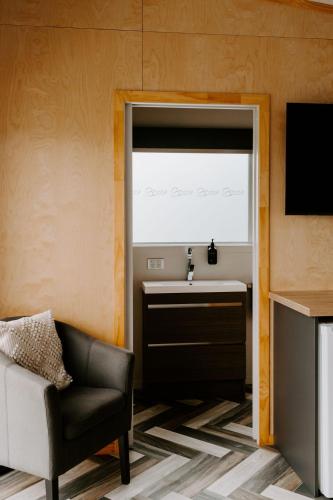 a living room with a chair and a sink and a window at Te Mata Views Resort in Havelock North