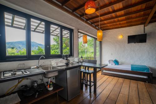 a kitchen with a sink and a bedroom with a bed at Salento Pequeño Hotel in Salento