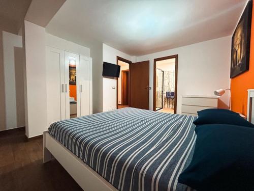 a bedroom with a large bed with a striped blanket at Villa Betta Cuntrariusa con piscina privata e jacuzzi a Scopello in Castellammare del Golfo