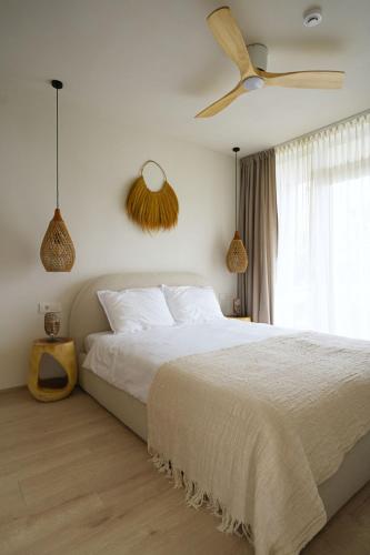 a bedroom with a white bed and a ceiling fan at Balimood Stay in Palanga