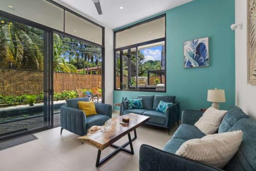 a living room with two blue couches and a table at Chic Bohemian Villa with a Private Swimming Pool and Stunning Outdoor Space in Coco