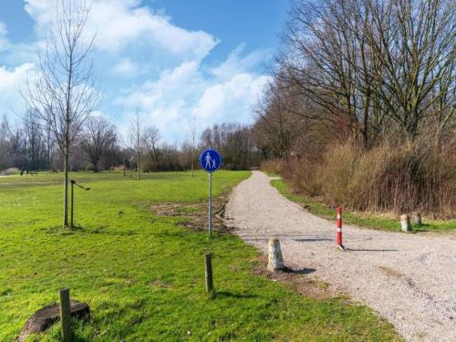 a blue sign on the side of a dirt road at Bungalow in South Holland by the Water in Simonshaven