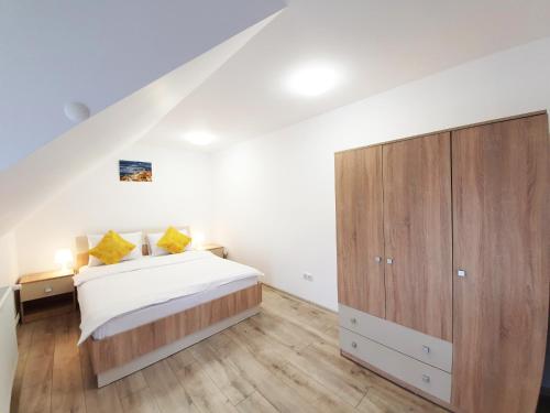 a bedroom with a bed and a wooden cabinet at Mont Melis in Sînpetru