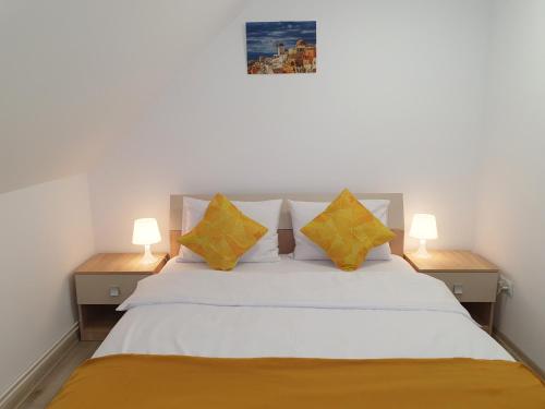 a bedroom with a white bed with two lamps at Mont Melis in Sînpetru