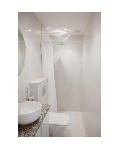 a white bathroom with a sink and a toilet at Sea&Sun Living in Ulcinj