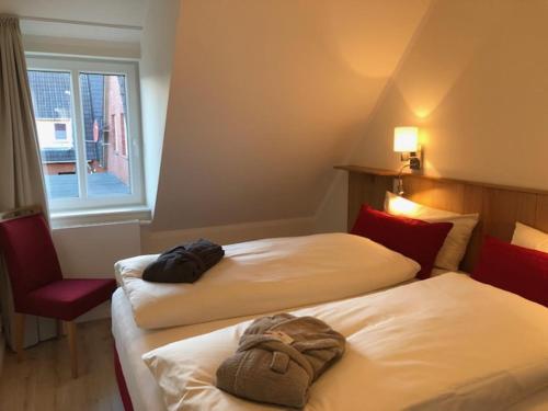 a hotel room with two beds and a window at Haus Ostwind OSTWIND 'Levenslüst' in Langeoog