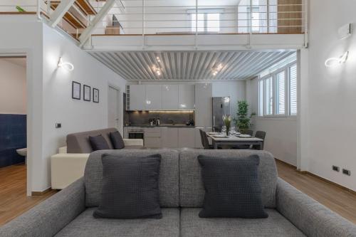 a living room with a couch and a kitchen at Valentini Luxury Loft-18 by train to Florence-PARKING FREE in Prato