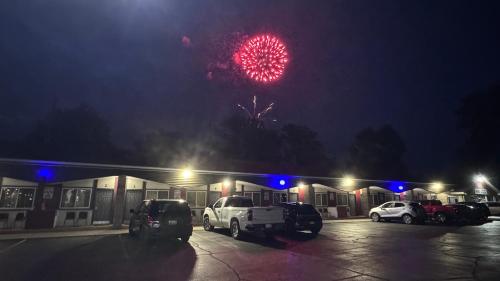 a firework display above a parking lot at night at Pinconning Trail Inn Motel in Pinconning