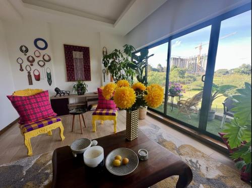 a living room with a vase of flowers on a table at Happy Place Apartment in Gatunga