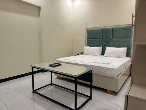 a bedroom with a bed and a table in it at Dove INN Express in Lahore