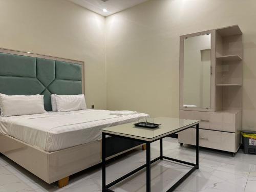 a bedroom with a bed and a table with a mirror at Dove INN Express in Lahore