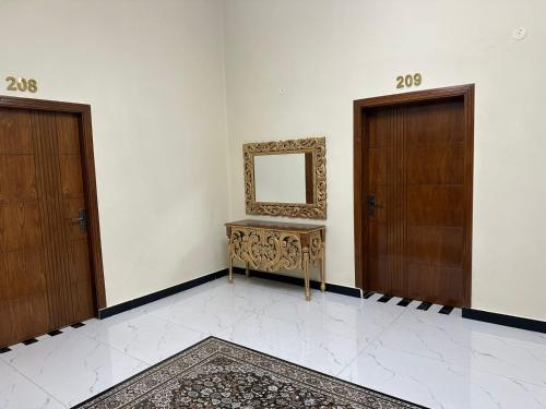 a room with two doors and a mirror on the wall at Dove INN Express in Lahore