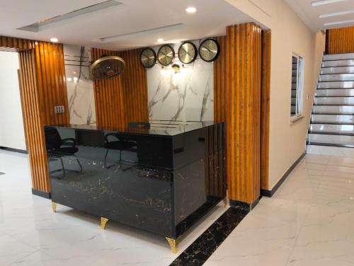a room with a desk and clocks on the wall at Dove INN Express in Lahore