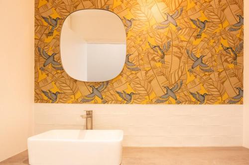 a bathroom with a mirror and a white sink at Maison d'architecte au coeur de la nature in Guichen